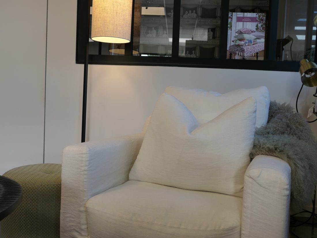 Fauteuil blanc et coussin dans l'espace mobilier du showroom